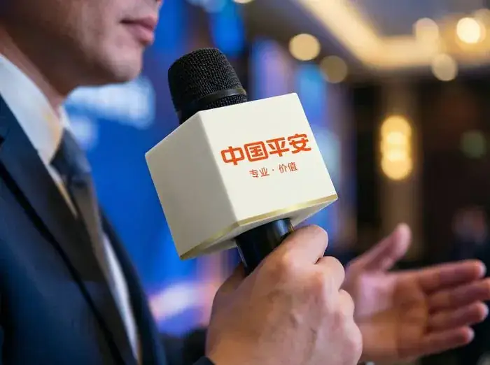 发言者手持带有中国平安橙红标识的米白色方形话筒牌